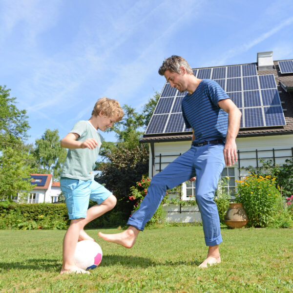 Vater und Sohn spielen im Garten Fußball