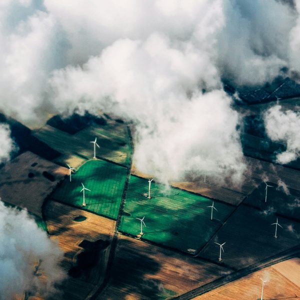 Landschaft aus Vogelperspektive mit Wolken, Feldern und Windrädern