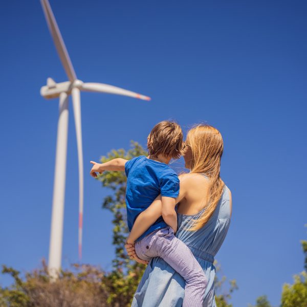 Mutter mit Kind auf dem Arm betrachten ein Windrad